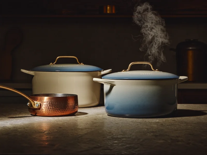 Casseruole in ghisa smaltata e pentolino con fondo in rame su piano in pietra